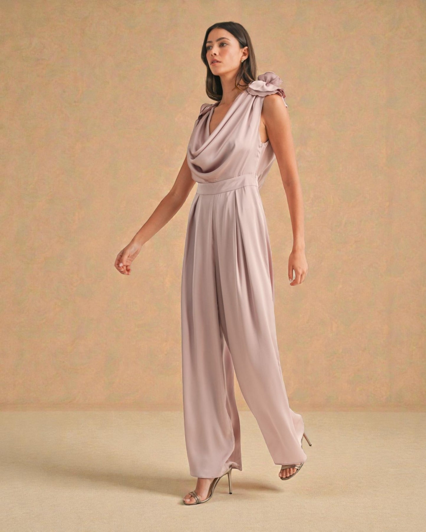 Woman wearing a light purple jumpsuit against a beige background