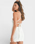 Woman wearing a white crochet dress on a white background