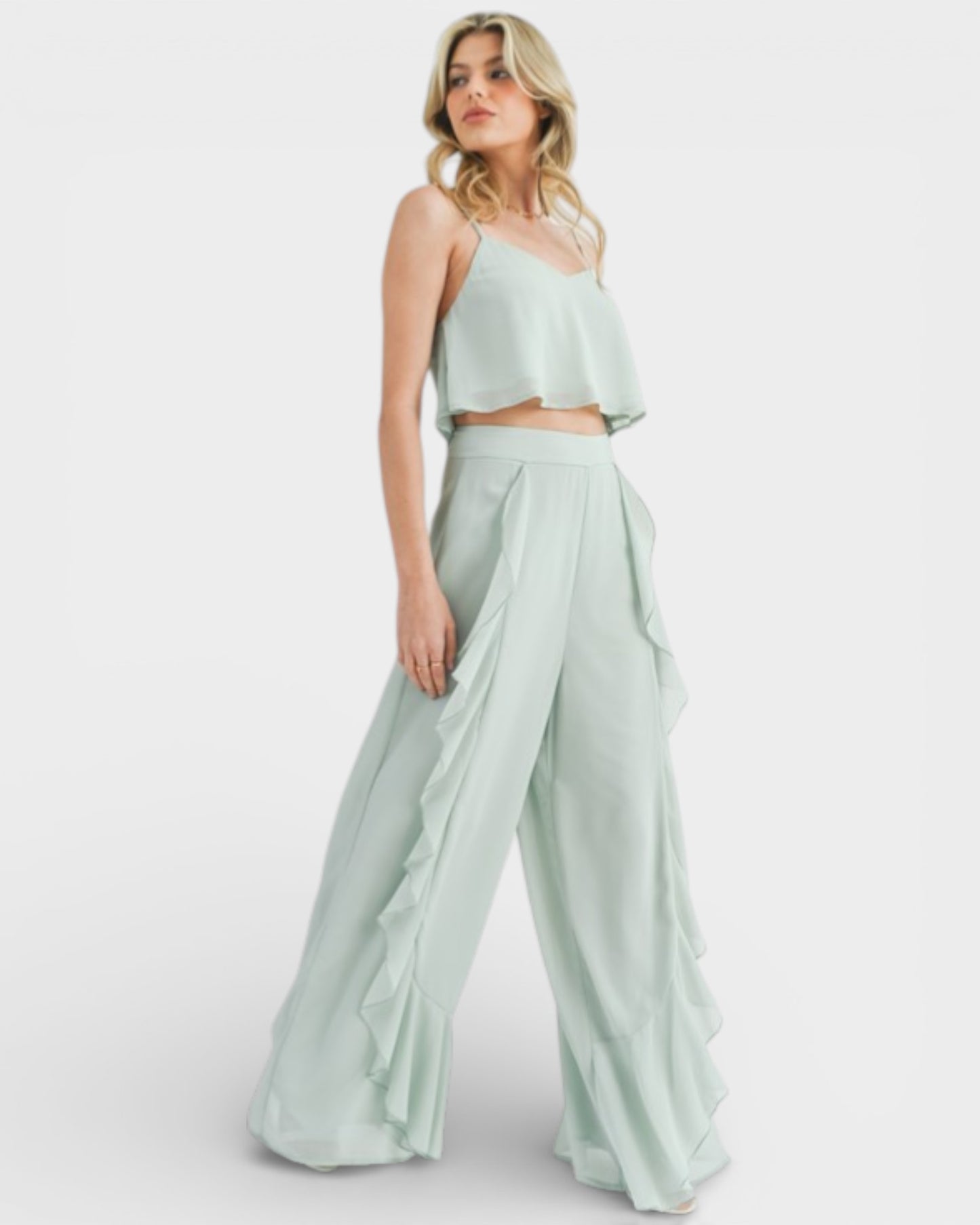 Woman wearing a light green two-piece outfit on a white background