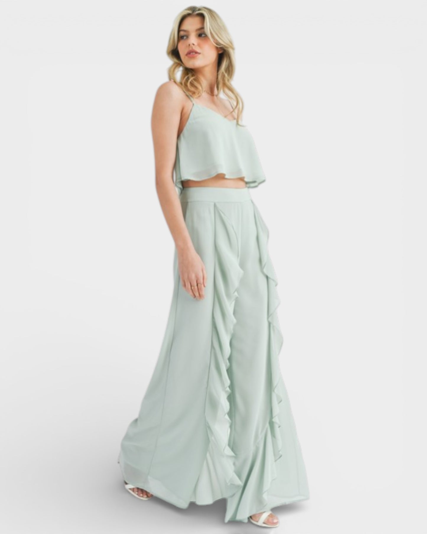 Woman wearing a light green two-piece outfit on a white background