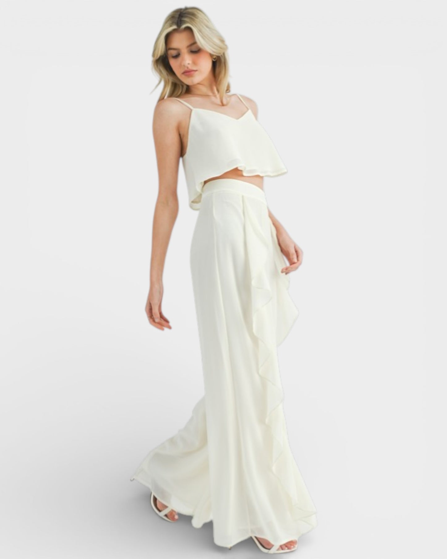 Woman wearing a white two-piece dress on a light gray background