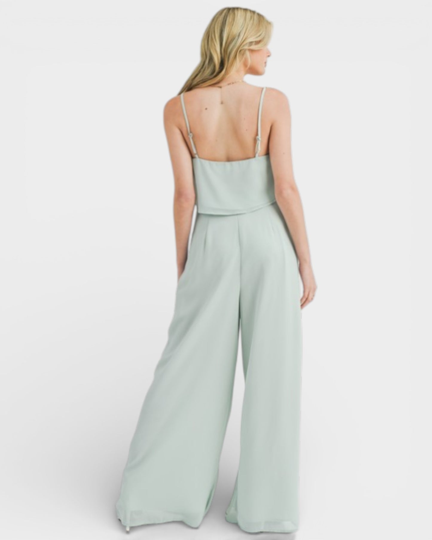 Woman wearing a light green jumpsuit on a white background