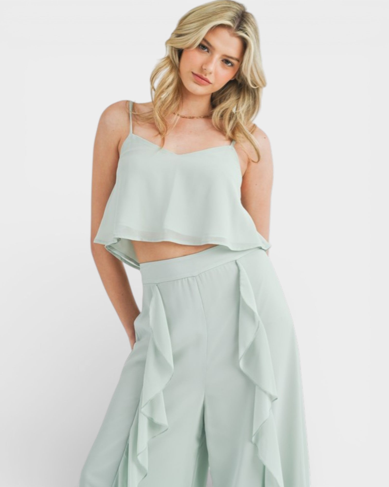 Woman wearing a light green two-piece outfit on a white background