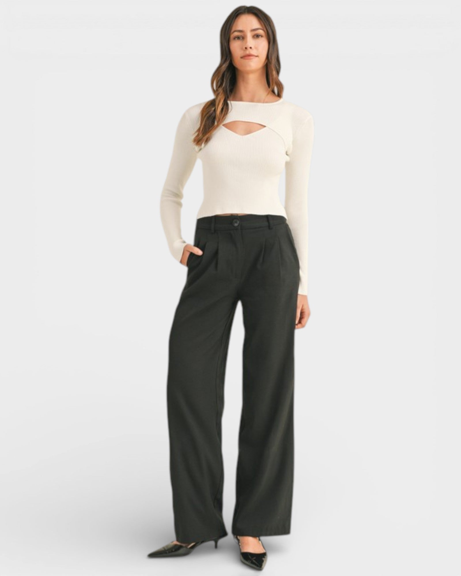 Person wearing a white shirt and green pants on a plain background