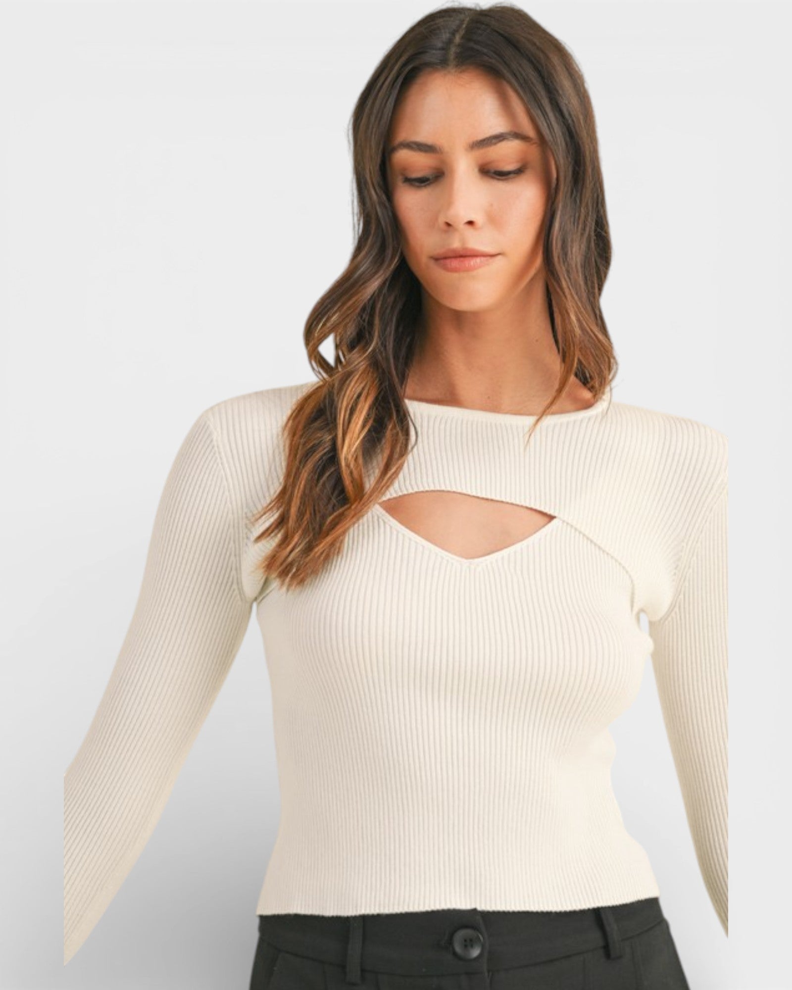 Woman wearing a beige ribbed sweater with cut-out design on a white background