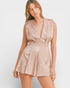 Woman wearing a beige sleeveless romper on a white background