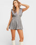 Woman wearing a gray sleeveless dress with a plain background