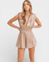 Woman wearing a beige romper against a white background
