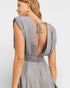 Woman wearing a gray dress with an open back on a light gray background