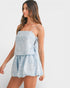 Woman wearing a light blue lace dress against a white background
