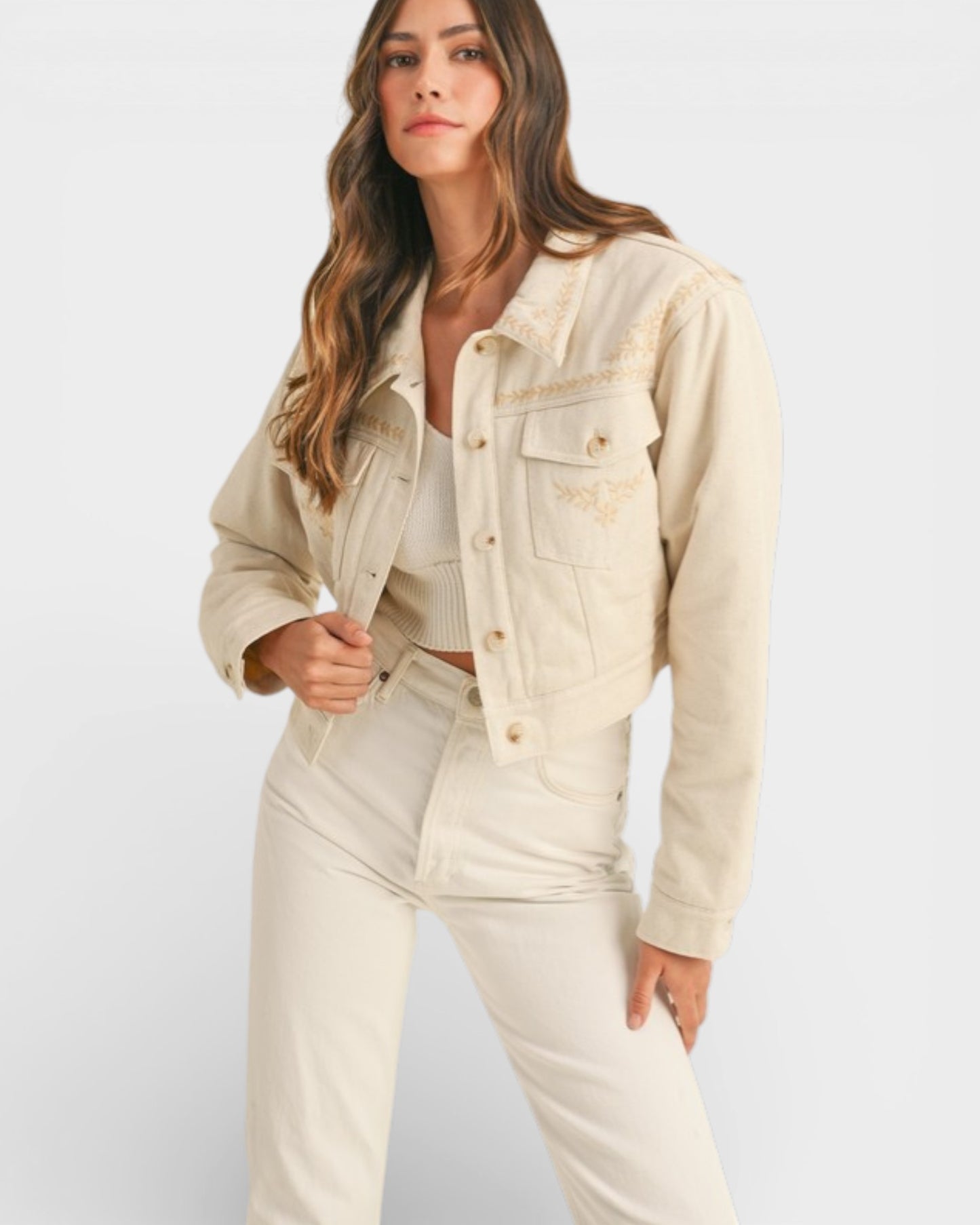 Woman wearing a beige denim jacket and pants on a white background