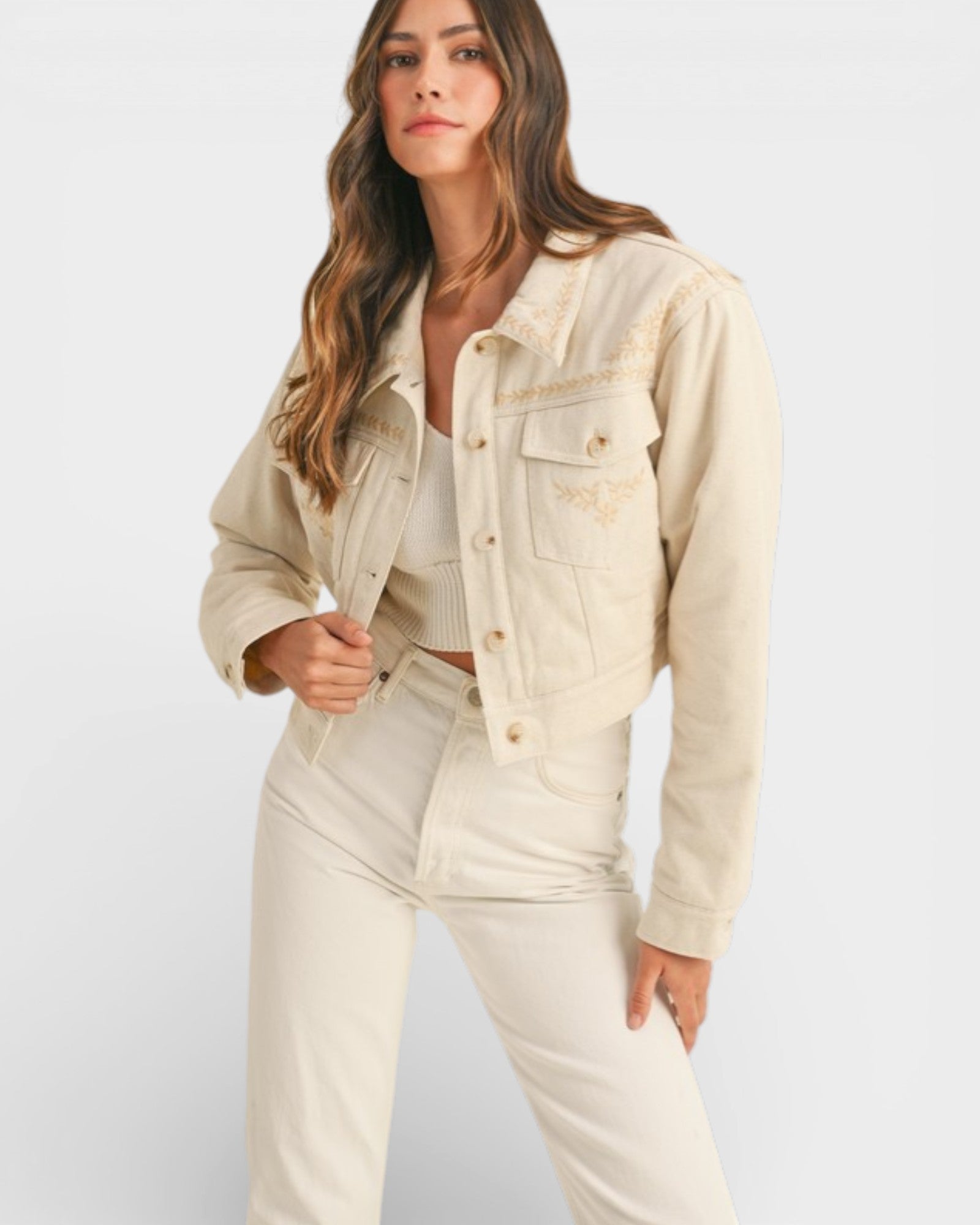 Woman wearing a beige denim jacket and pants on a white background