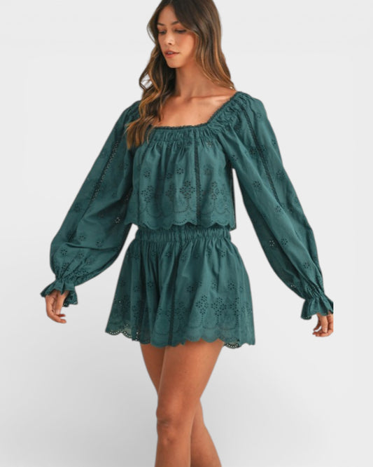 Woman wearing a green dress with long sleeves on a white background