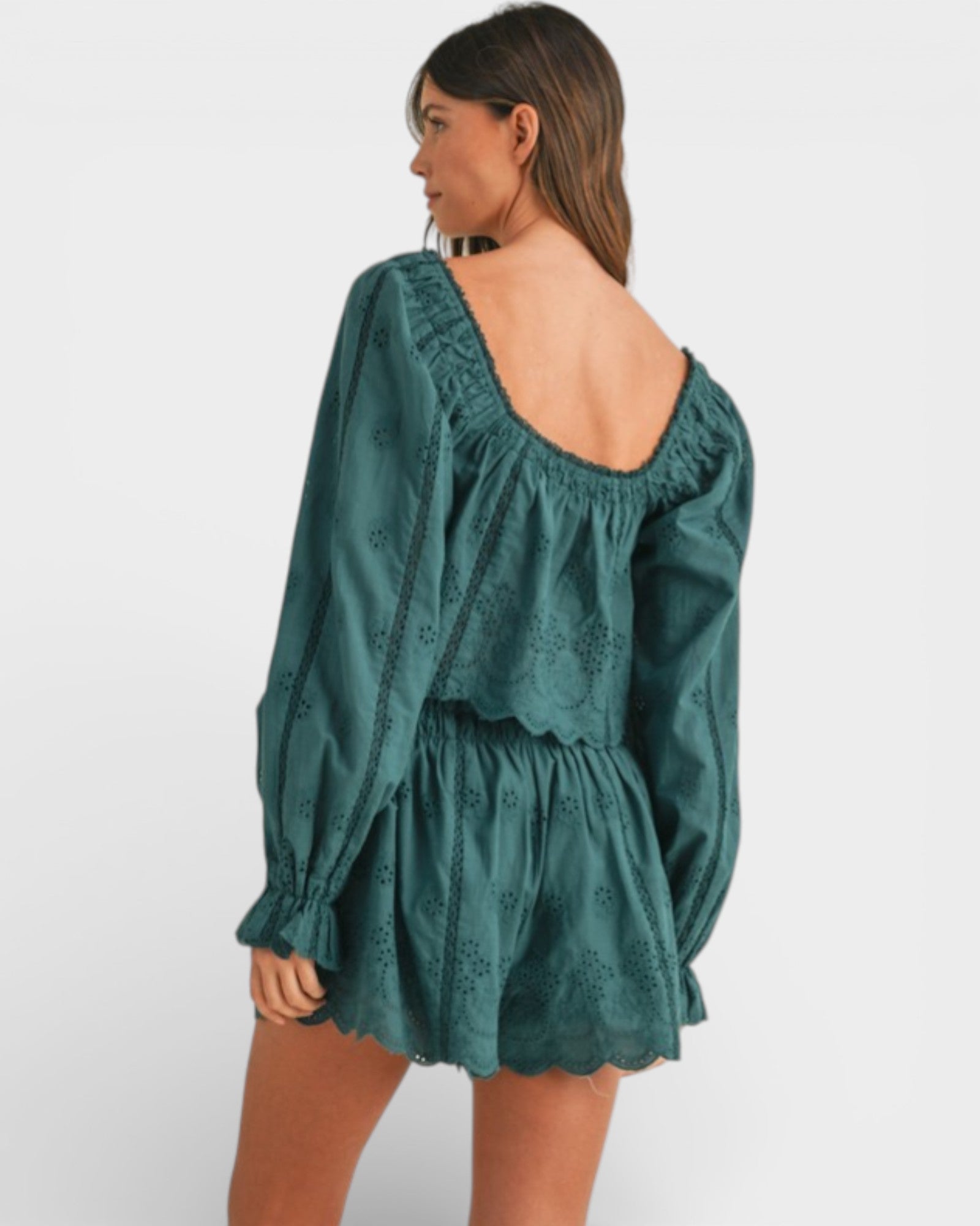 Woman wearing a green dress with long sleeves on a white background