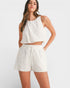 Woman wearing a white sleeveless top and shorts set on a white background