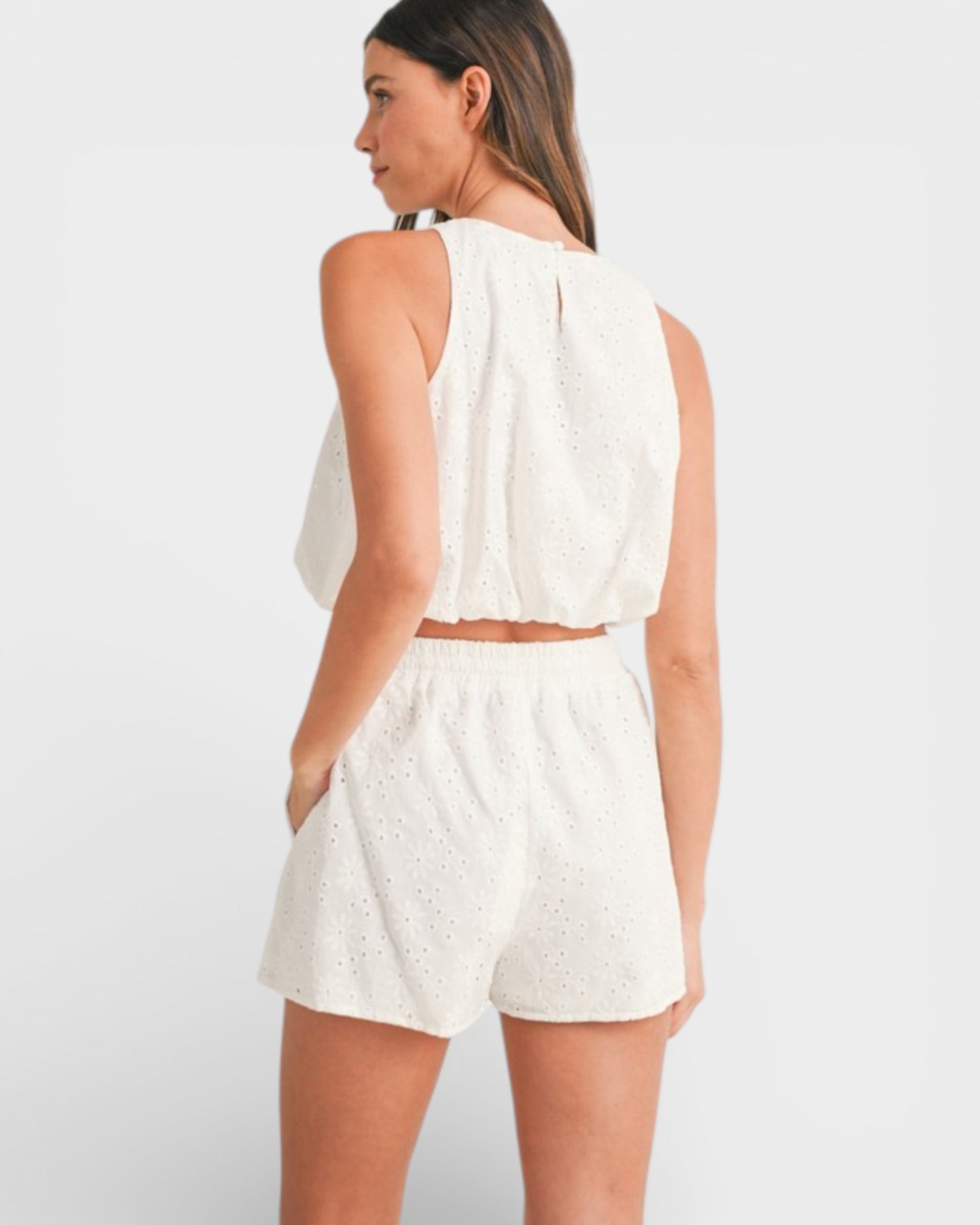 Woman wearing a white outfit on a plain background