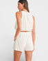 Woman wearing a white outfit on a plain background