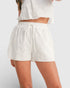 White shorts with a subtle pattern worn by a person on a plain background