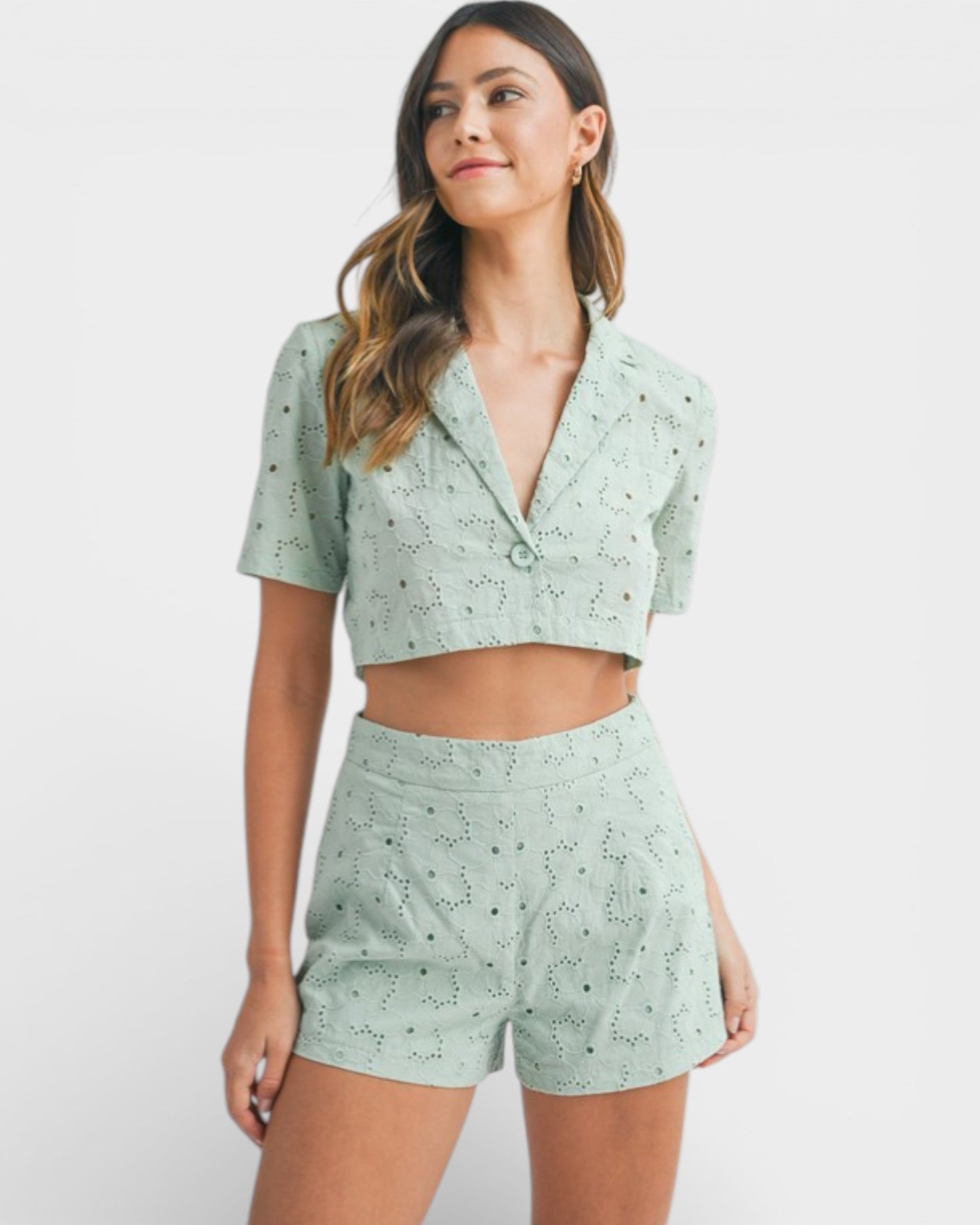 Woman wearing a light green patterned outfit on a white background