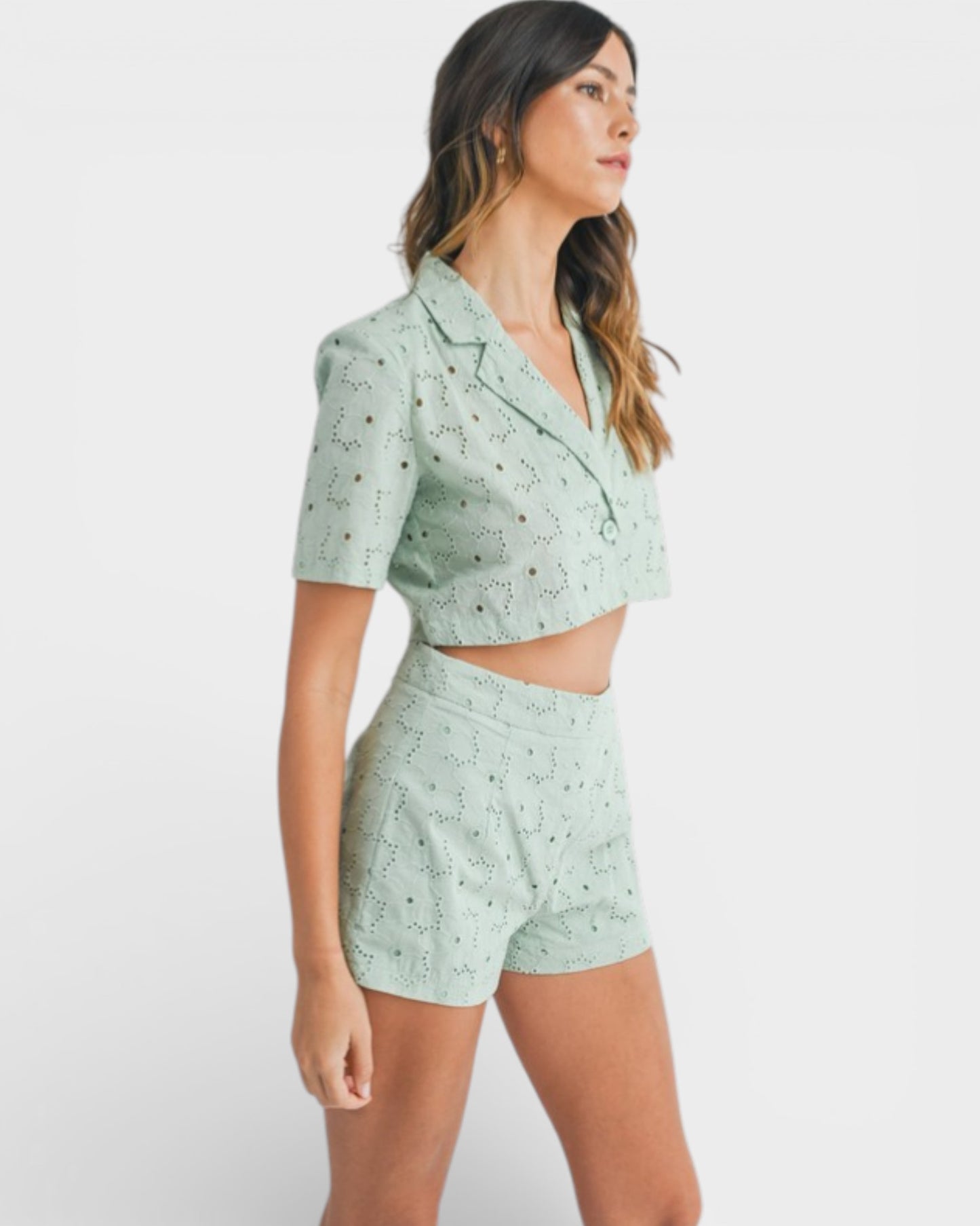 Woman wearing a light green patterned outfit on a white background