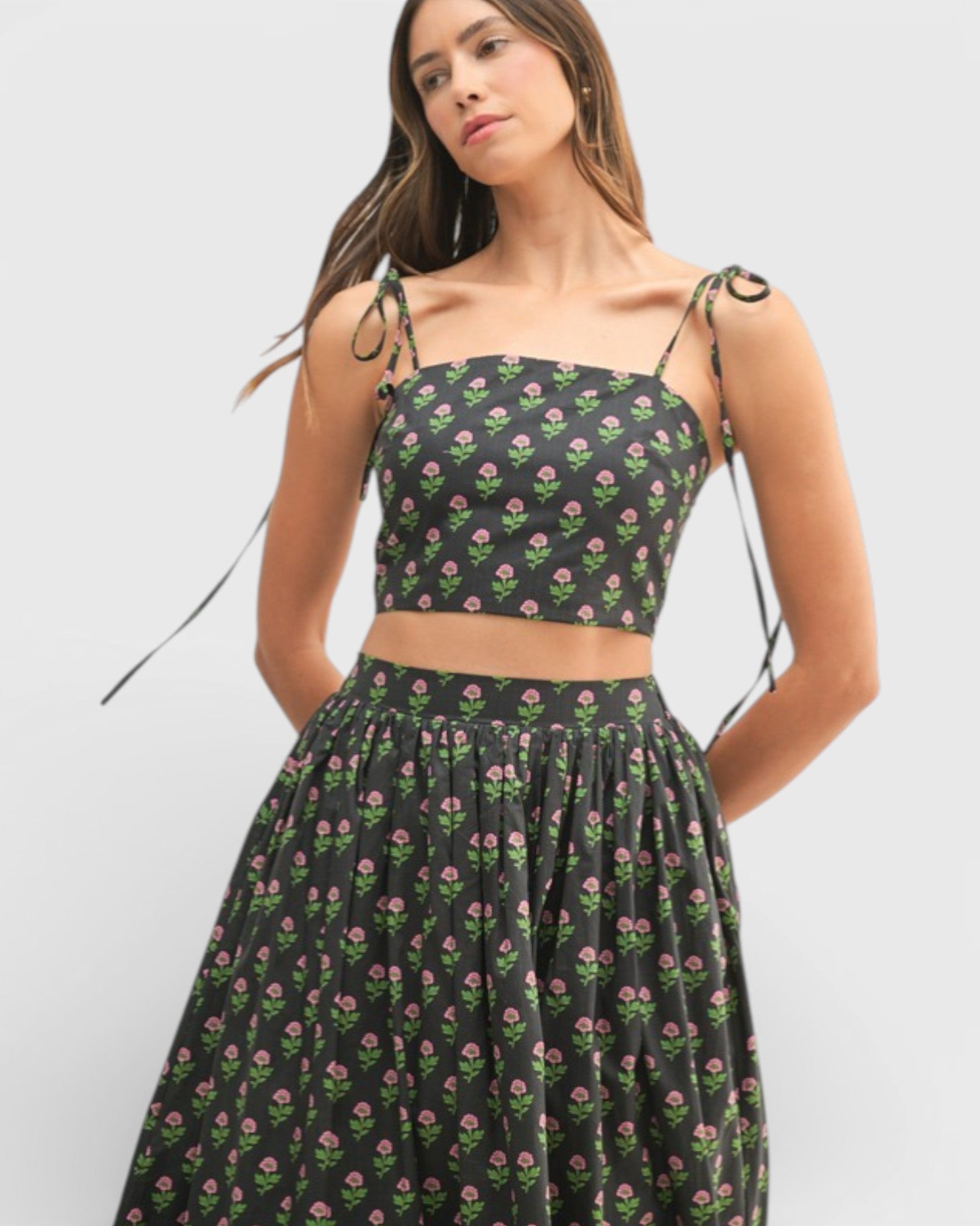 Woman wearing a black floral two-piece outfit on a white background