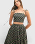 Woman wearing a black floral two-piece outfit on a white background