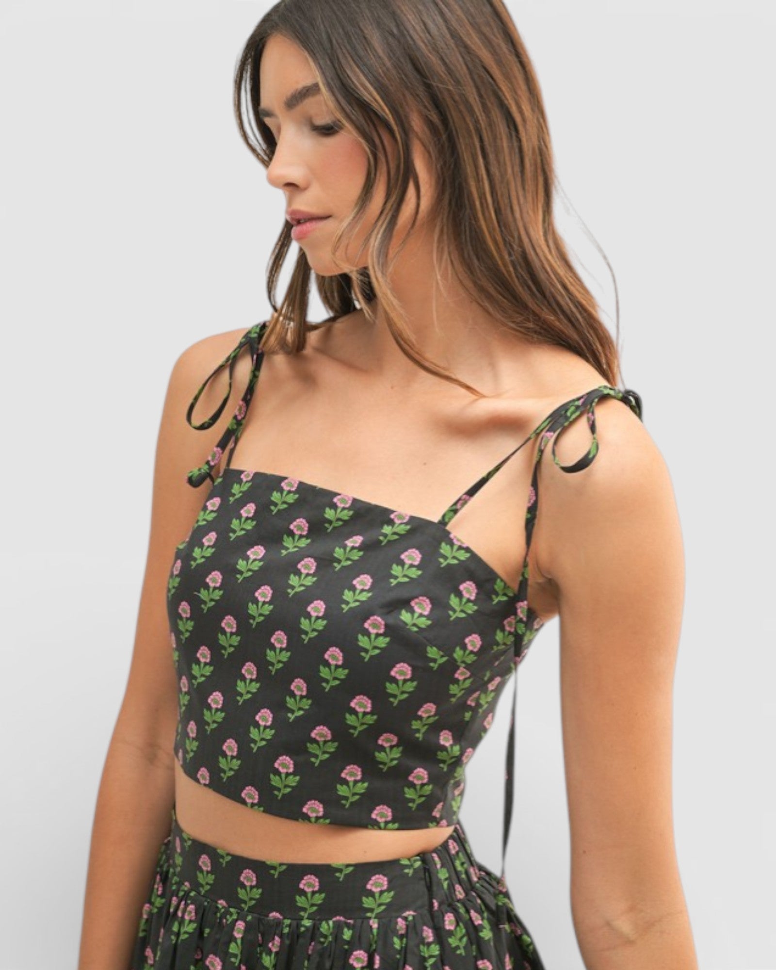 Woman wearing a black floral top against a white background