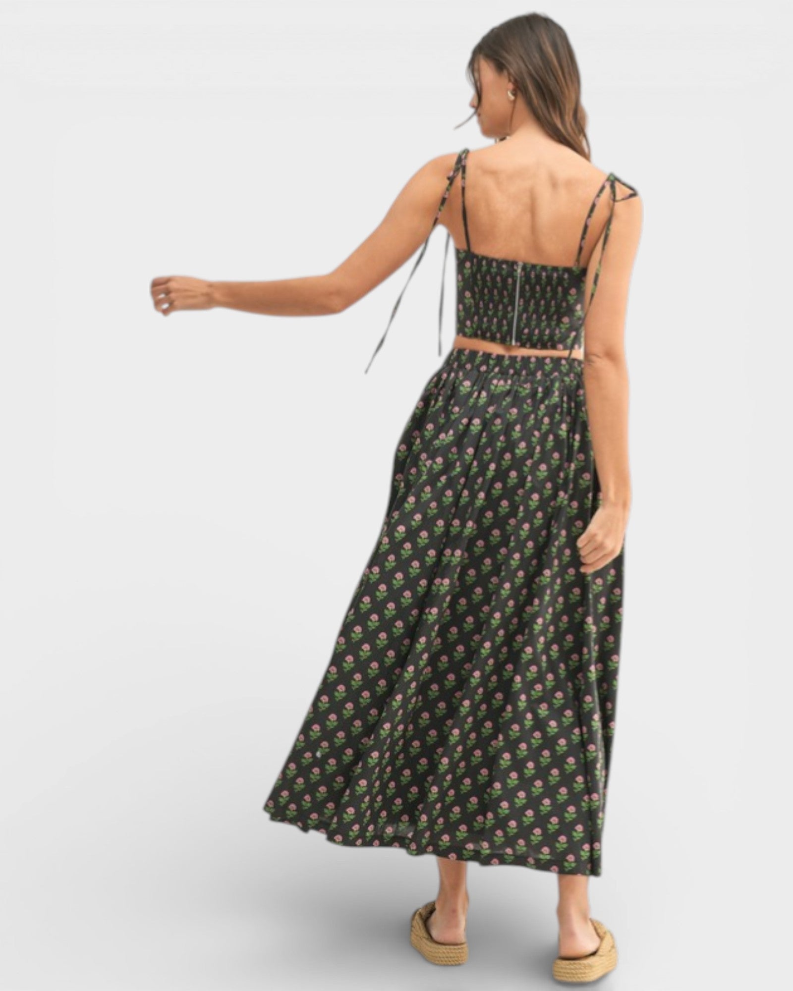 Woman wearing a floral dress with thin straps on a white background