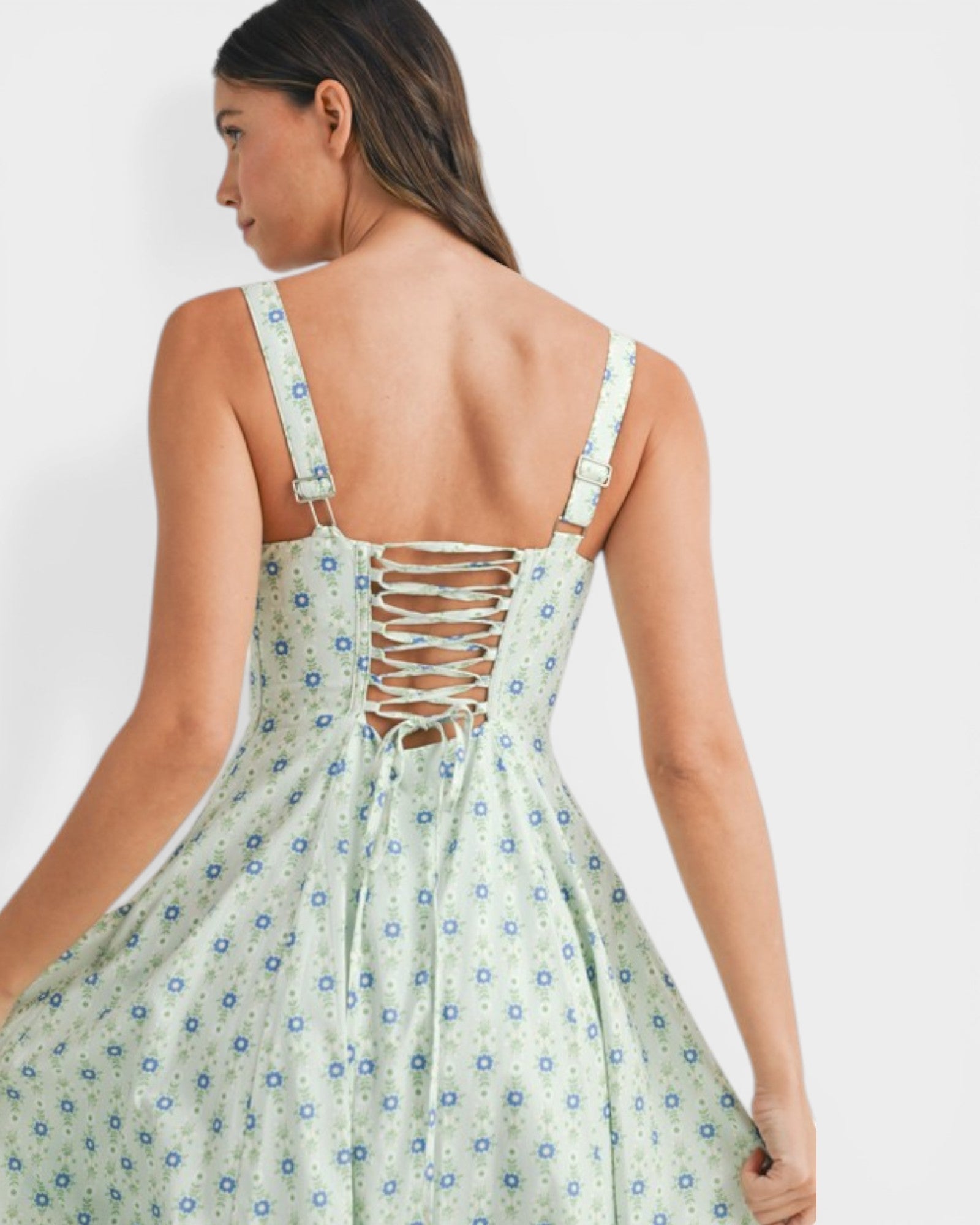 Woman wearing a floral dress with a backless design on a white background