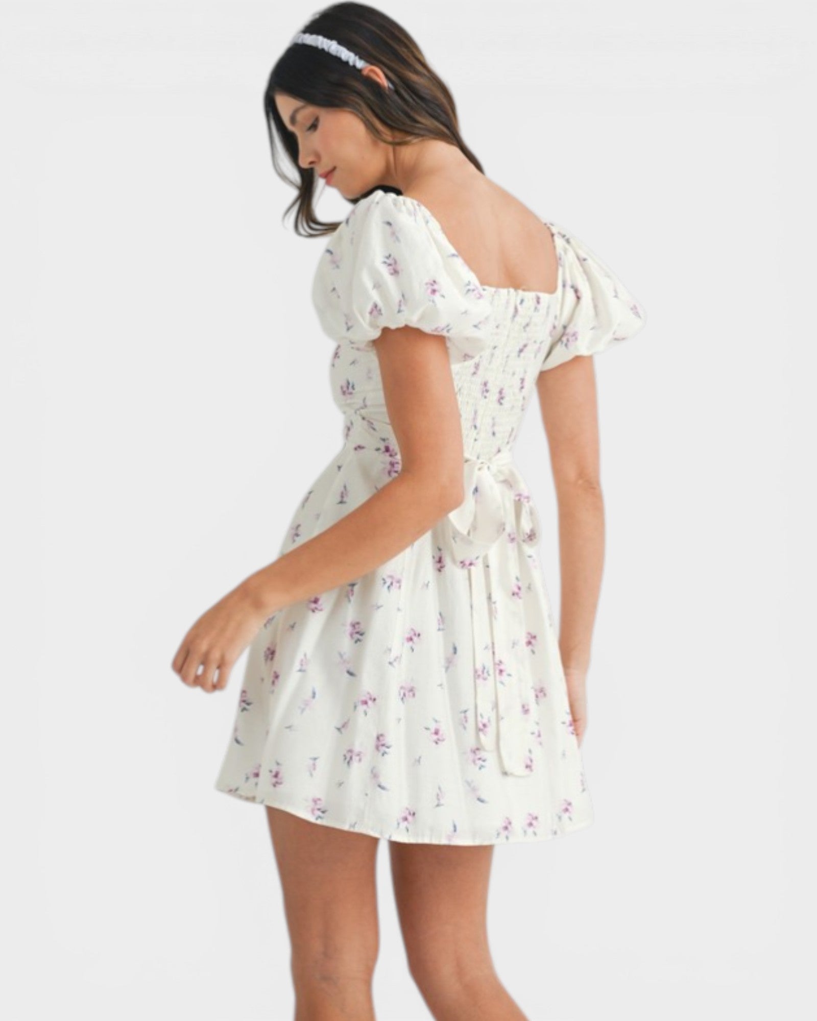 Woman wearing a white floral dress on a white background