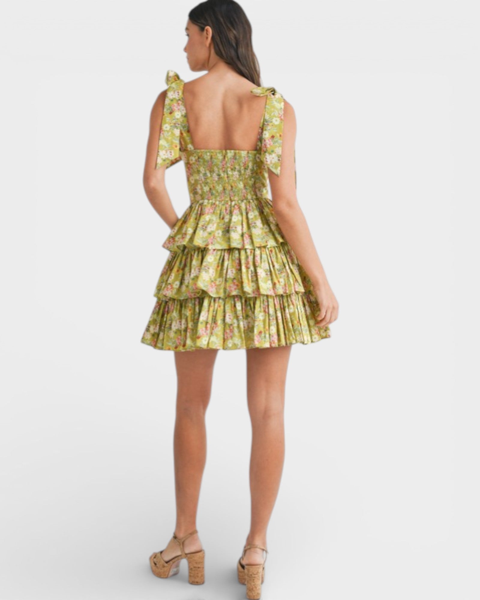 Woman wearing a green floral dress on a white background