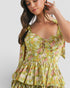 Woman wearing a yellow floral dress against a white background