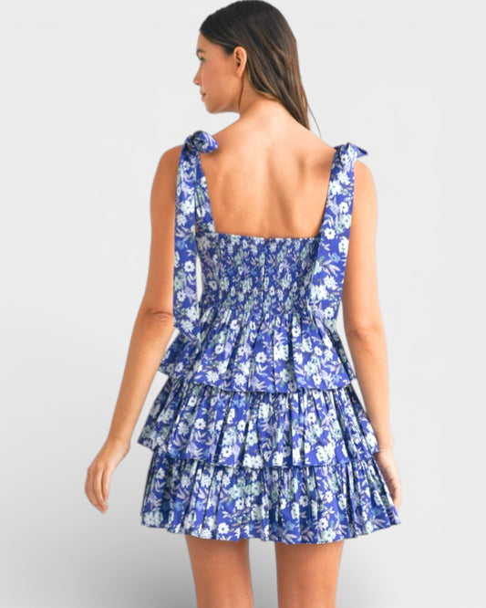 Woman wearing a blue floral dress on a light gray background