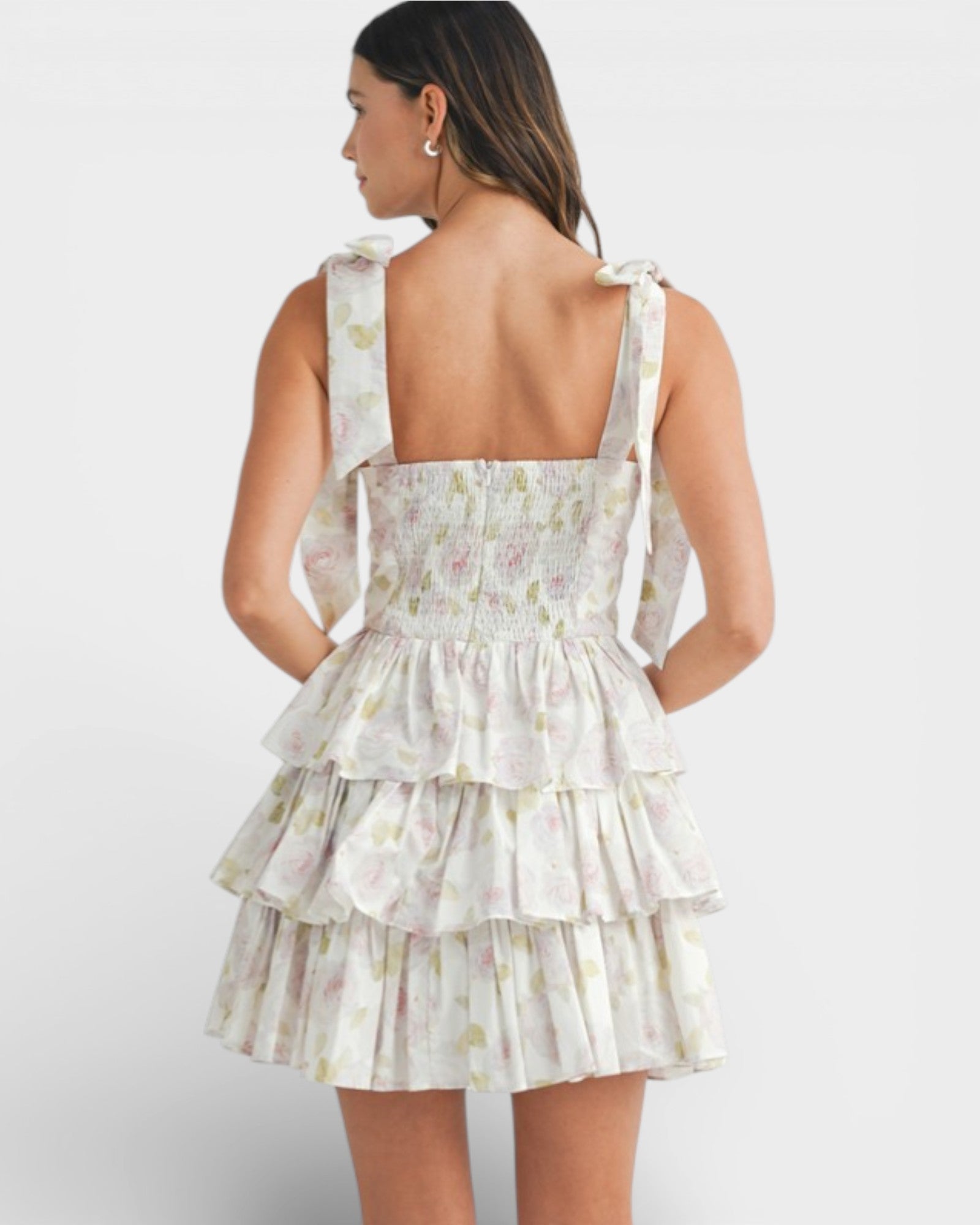 Woman wearing a floral tiered dress on a white background