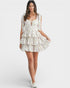 Woman wearing a floral tiered dress on a white background