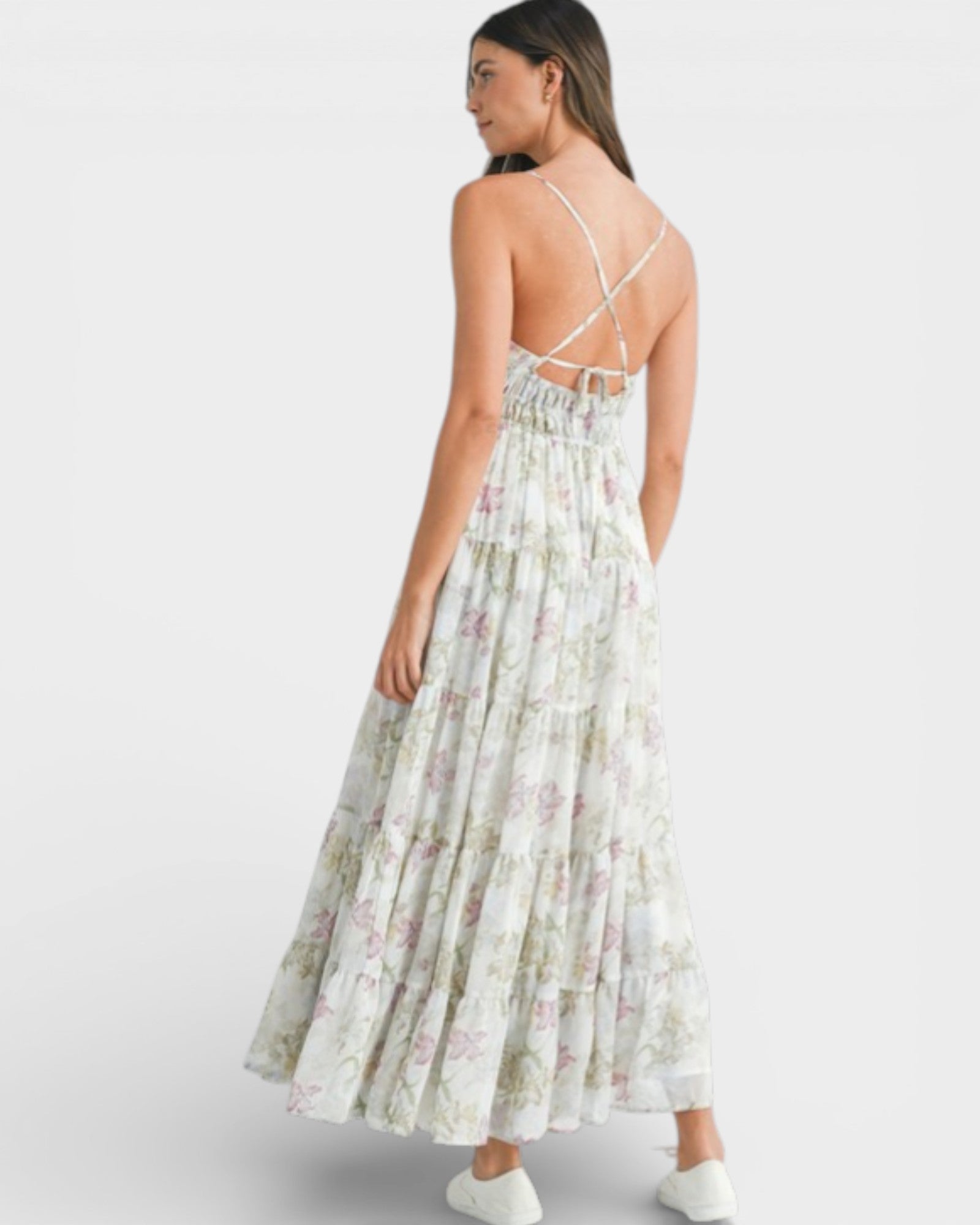 Woman wearing a floral dress with thin straps on a white background