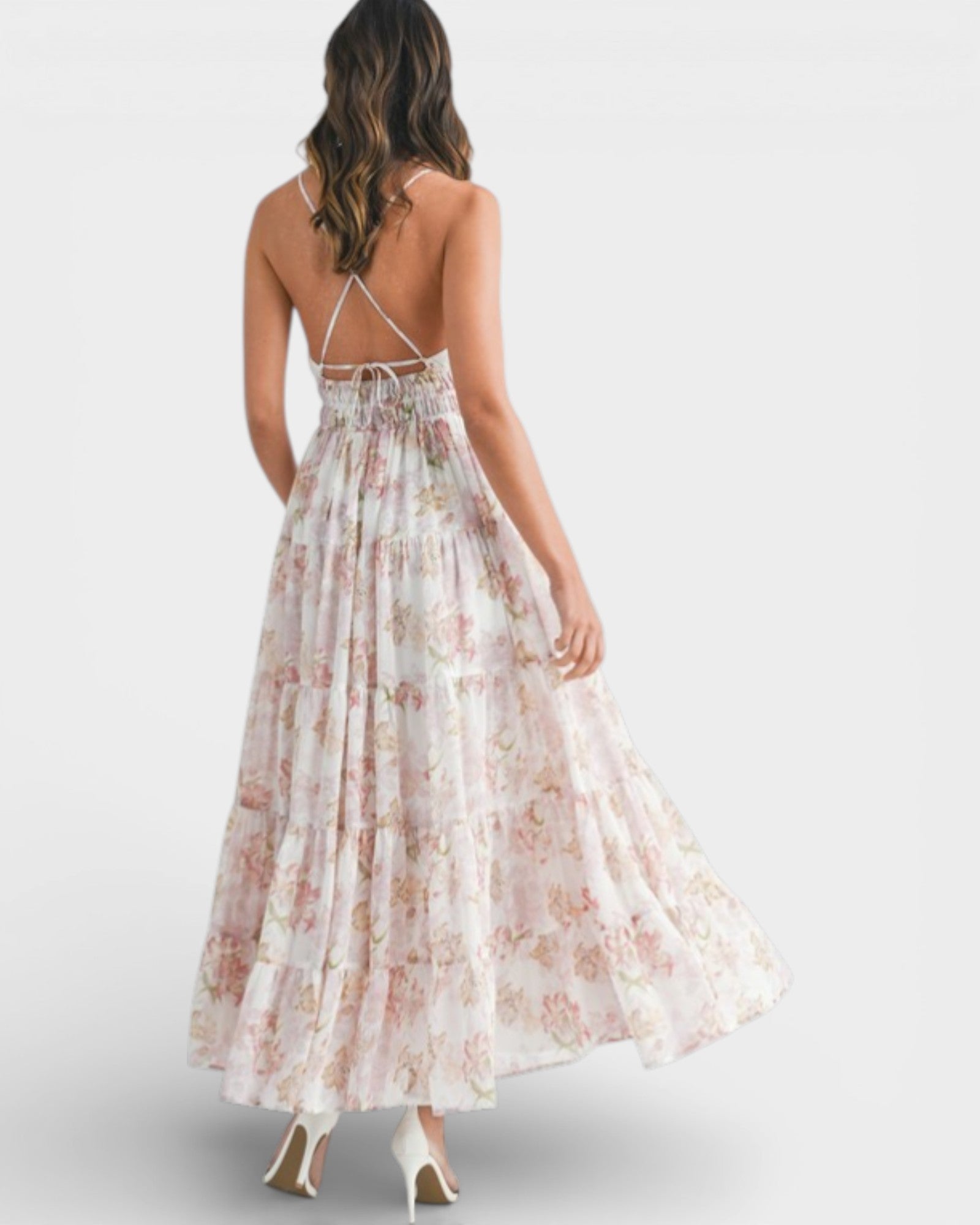 Woman wearing a floral dress with thin straps on a white background