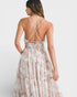 Woman wearing a floral dress with thin straps on a white background