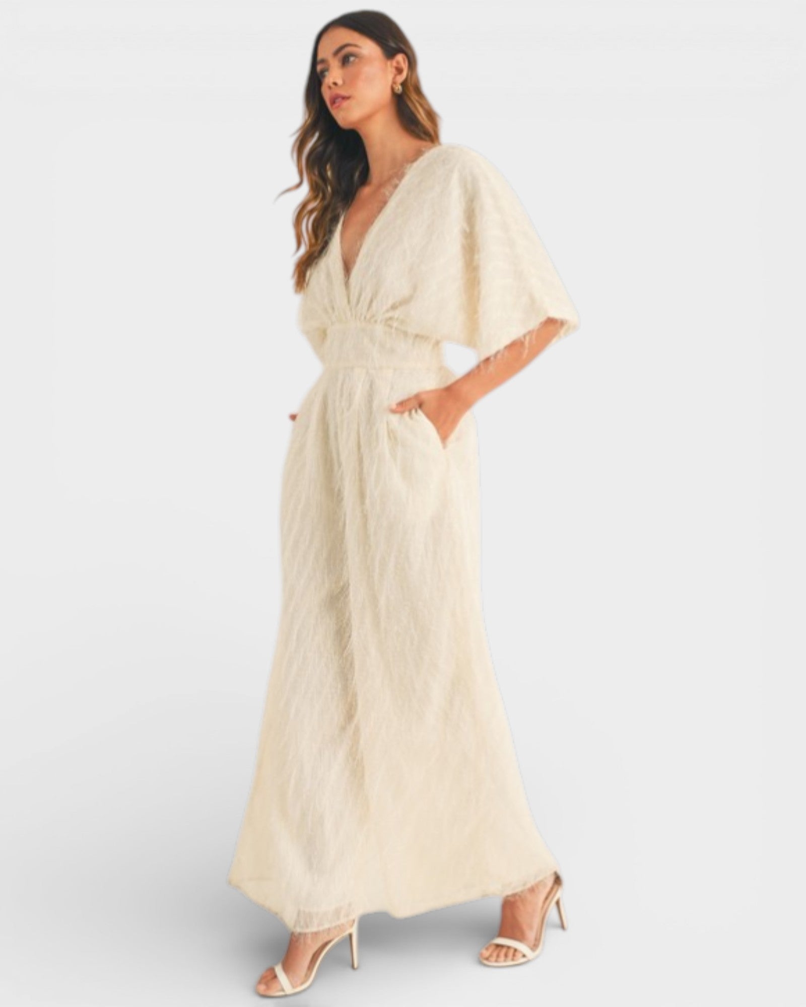 Woman wearing a beige dress with a plain background