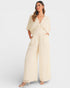 Woman wearing a beige jumpsuit on a white background