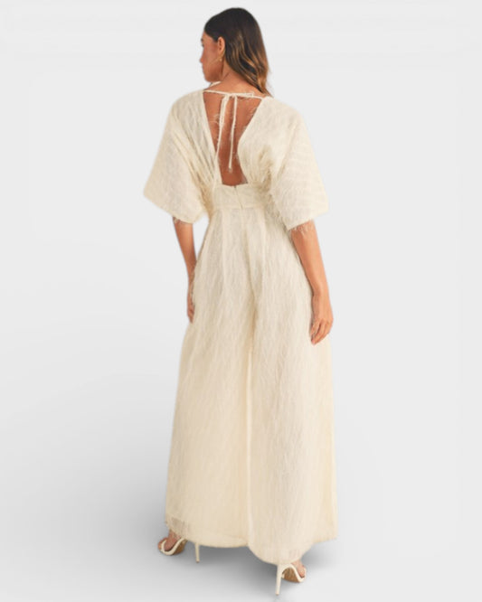 Woman wearing a beige dress with a backless design on a white background