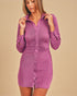 Woman wearing a purple button-up dress against a beige background