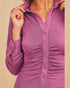 Purple button-up shirt worn by a person on a beige background