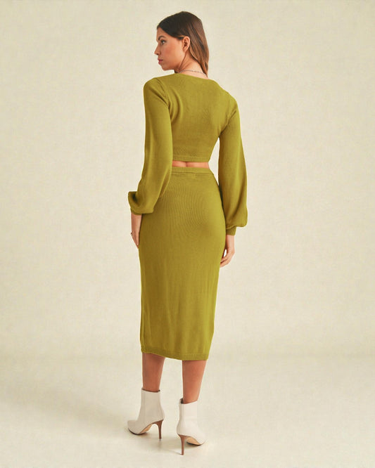 Woman wearing a green dress with long sleeves on a beige background