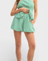 Green checkered romper worn by a person on a white background