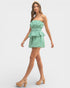 Woman wearing a green checkered strapless dress on a white background