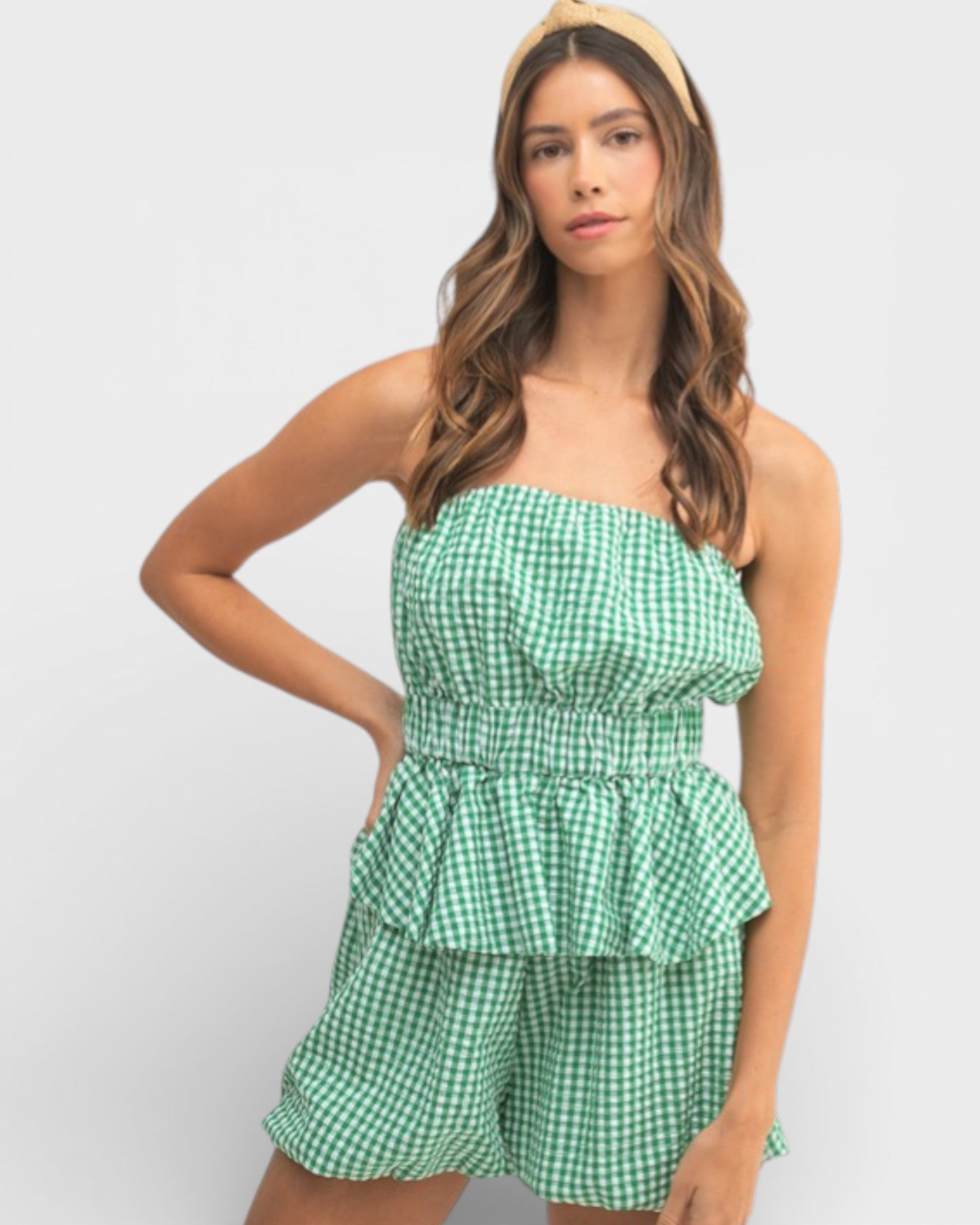 Woman wearing a green checkered strapless top and shorts on a white background