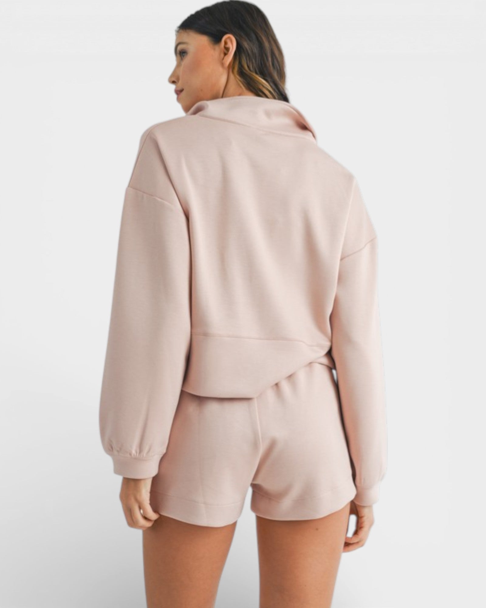 Woman wearing a light pink outfit on a white background