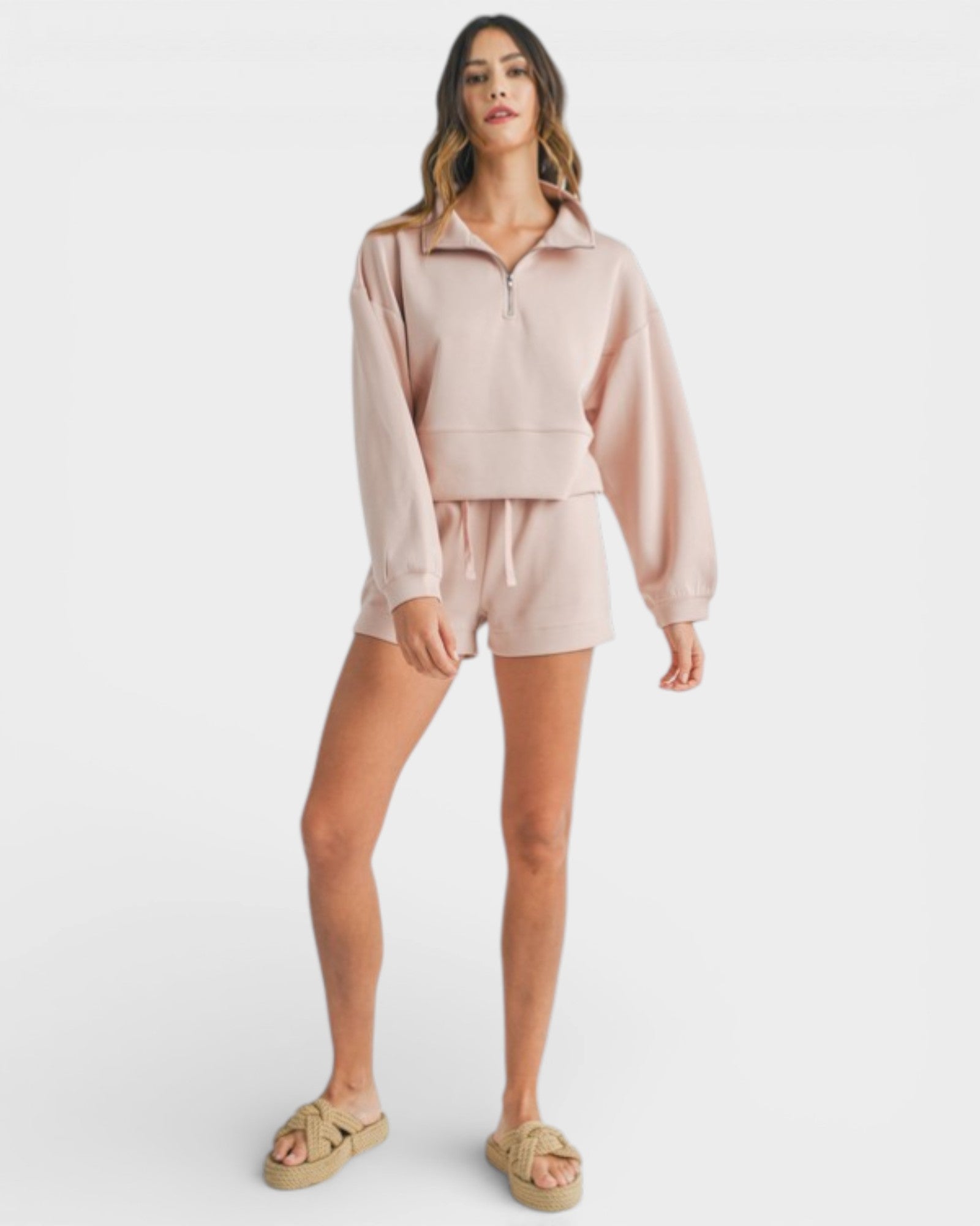 Woman wearing a light pink outfit on a white background