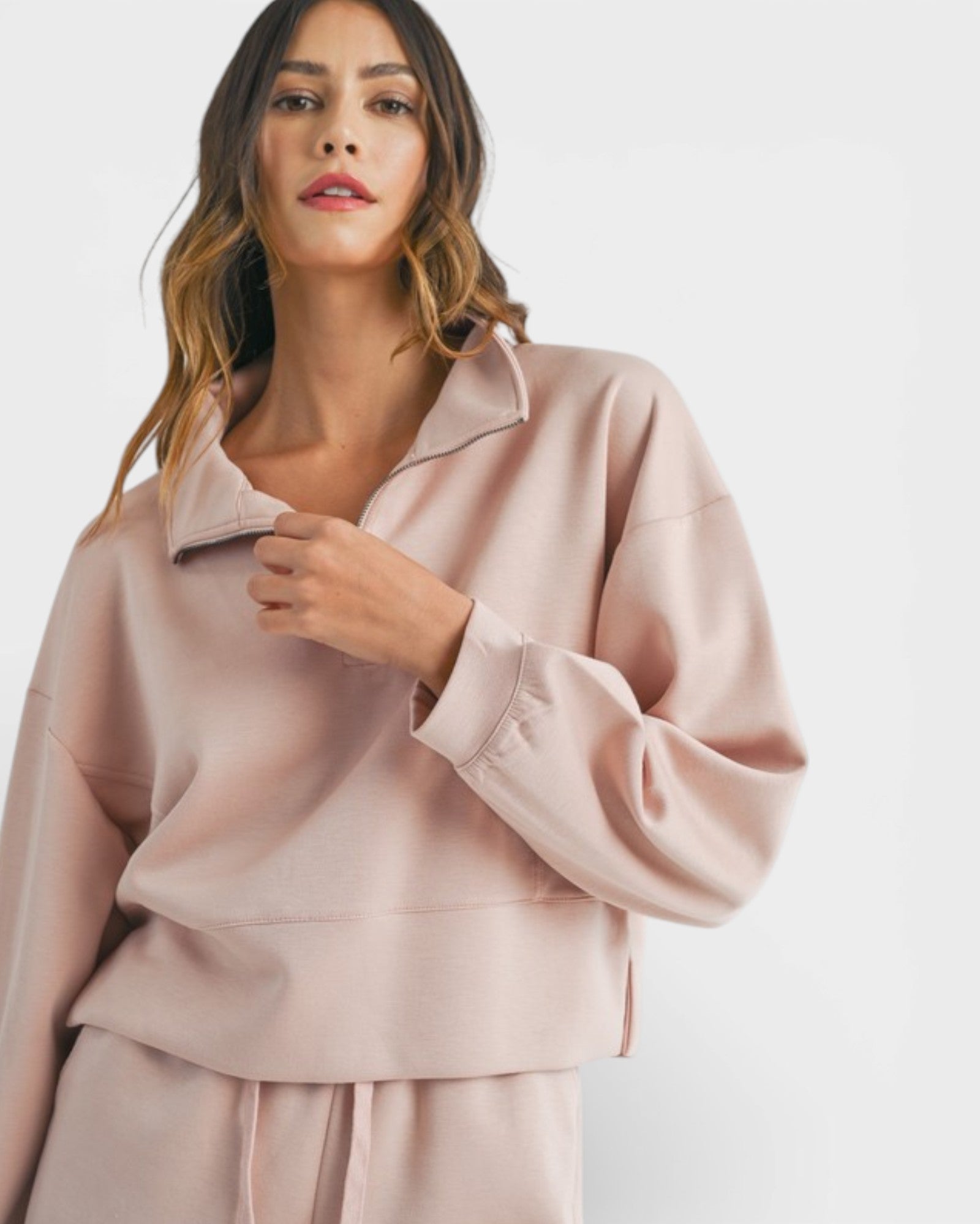Woman wearing a light pink outfit on a white background